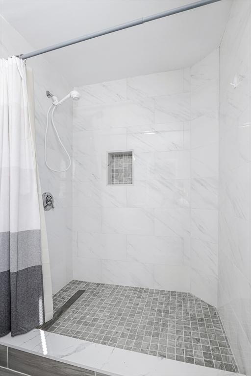 full bathroom featuring tiled shower