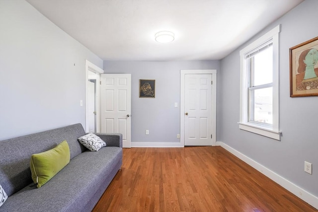 living area featuring baseboards and wood finished floors