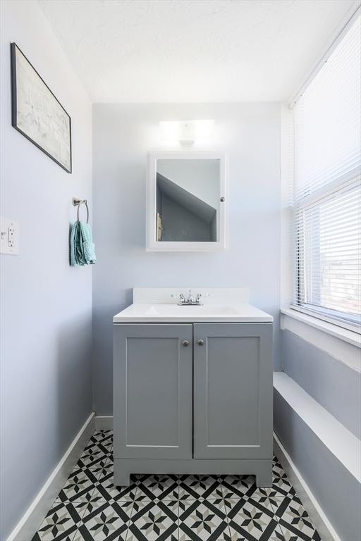 bathroom with tile patterned floors, baseboards, and vanity