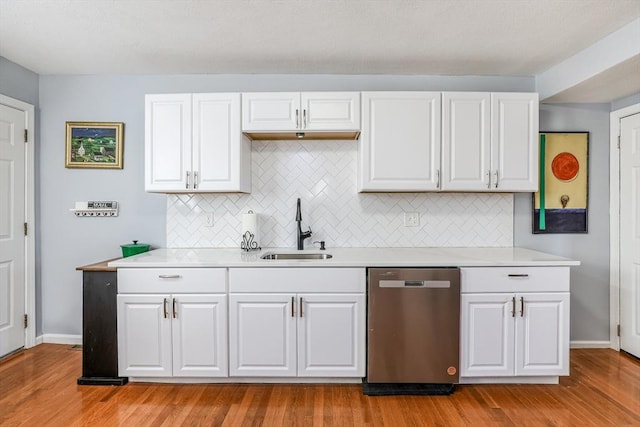 kitchen with white cabinets, light countertops, dishwasher, and a sink