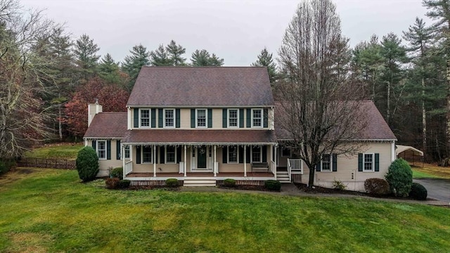 colonial house featuring a front lawn and covered porch