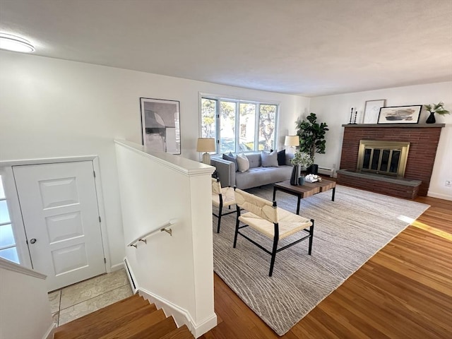 living room with a fireplace, a baseboard radiator, and hardwood / wood-style floors