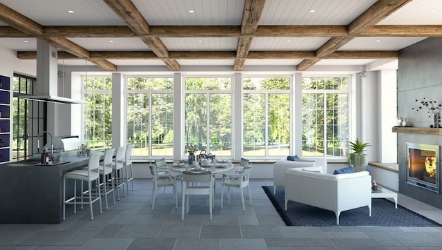 unfurnished sunroom featuring coffered ceiling, beam ceiling, and a wealth of natural light