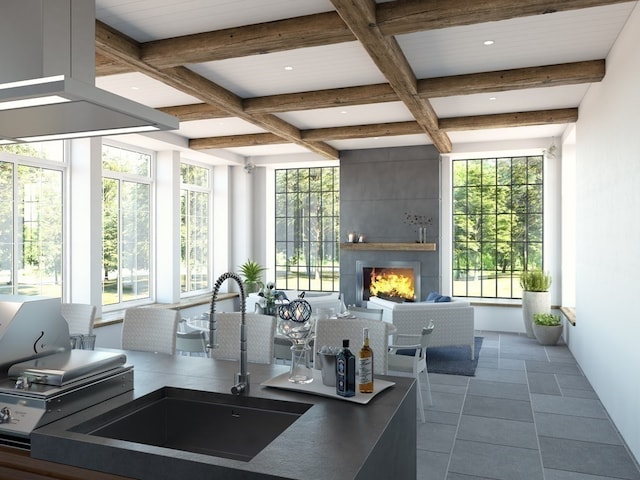 interior space featuring coffered ceiling, sink, a large fireplace, and plenty of natural light