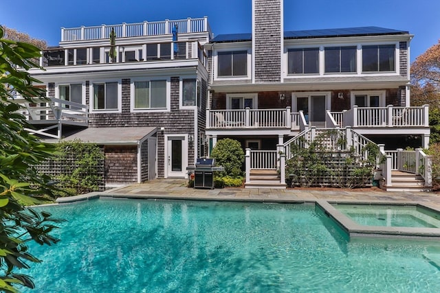 view of pool with an in ground hot tub