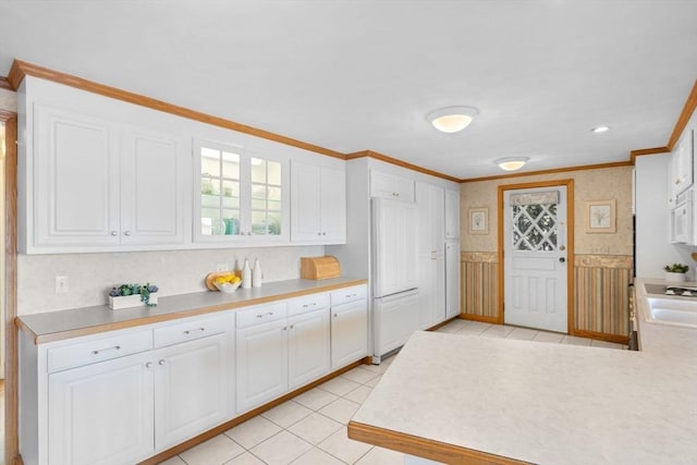 kitchen featuring light countertops, white cabinets, and ornamental molding