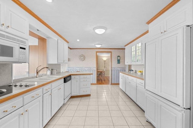 kitchen with white microwave, wallpapered walls, a wainscoted wall, dishwasher, and ornamental molding