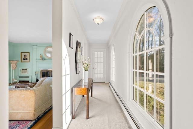 corridor featuring crown molding, a healthy amount of sunlight, a baseboard radiator, and light carpet