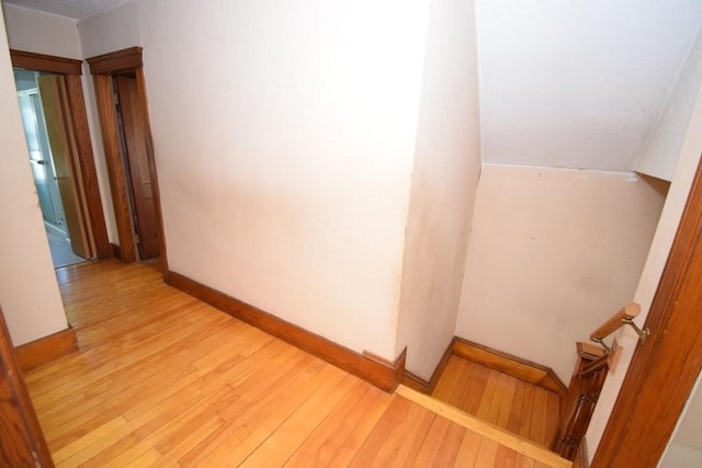 hallway featuring baseboards and light wood-style flooring