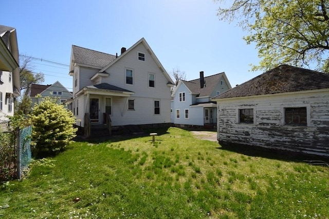 back of property with fence and a yard