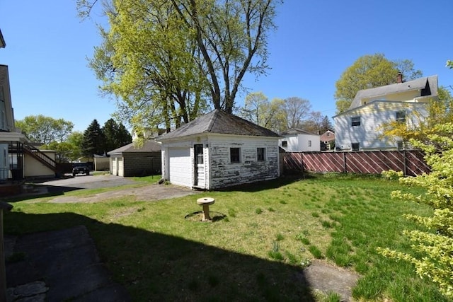 view of yard with an outdoor structure, a garage, and fence