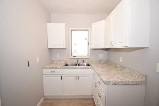 kitchen featuring a sink, light countertops, and white cabinetry