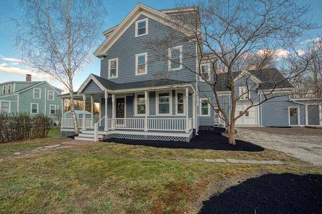 view of front facade with a porch, a garage, and a front lawn