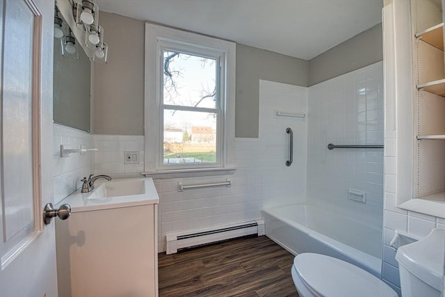 full bathroom with a baseboard radiator, hardwood / wood-style floors, toilet, vanity, and tile walls