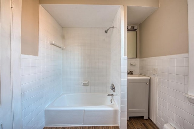 bathroom featuring tiled shower / bath, hardwood / wood-style floors, vanity, and tile walls