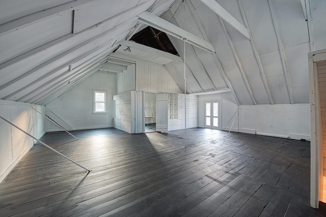 additional living space featuring plenty of natural light, dark wood-type flooring, and vaulted ceiling