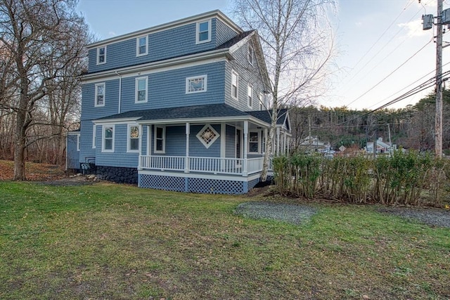 rear view of house with a porch and a yard