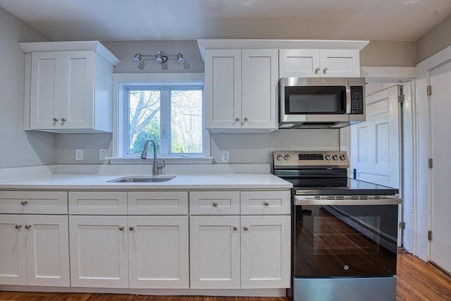 kitchen featuring white cabinets, hardwood / wood-style floors, stainless steel appliances, and sink