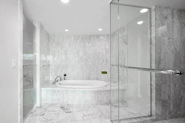 bathroom featuring tile walls and separate shower and tub