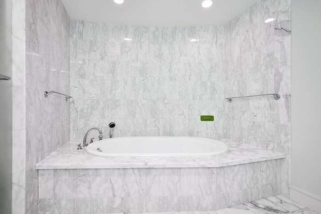 bathroom featuring tiled bath and tile walls