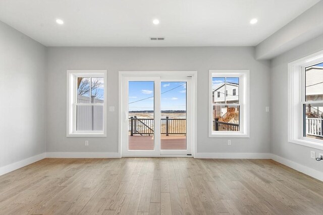 unfurnished room with recessed lighting, baseboards, visible vents, and light wood finished floors