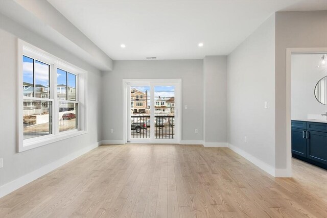 spare room featuring recessed lighting, light wood-style flooring, and baseboards