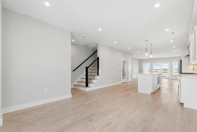 kitchen with a kitchen island, recessed lighting, light countertops, white cabinetry, and light wood-type flooring