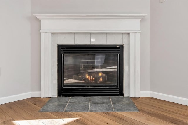 room details featuring hardwood / wood-style flooring and a tile fireplace