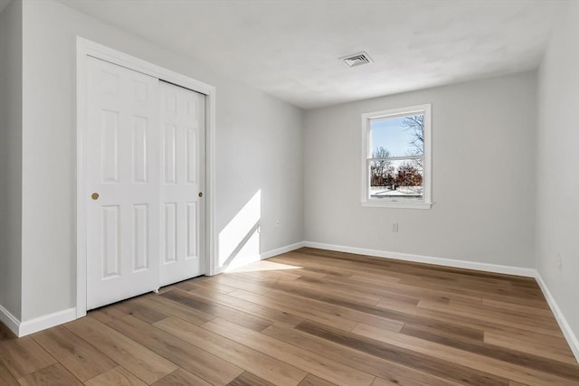 unfurnished bedroom with a closet and light wood-type flooring