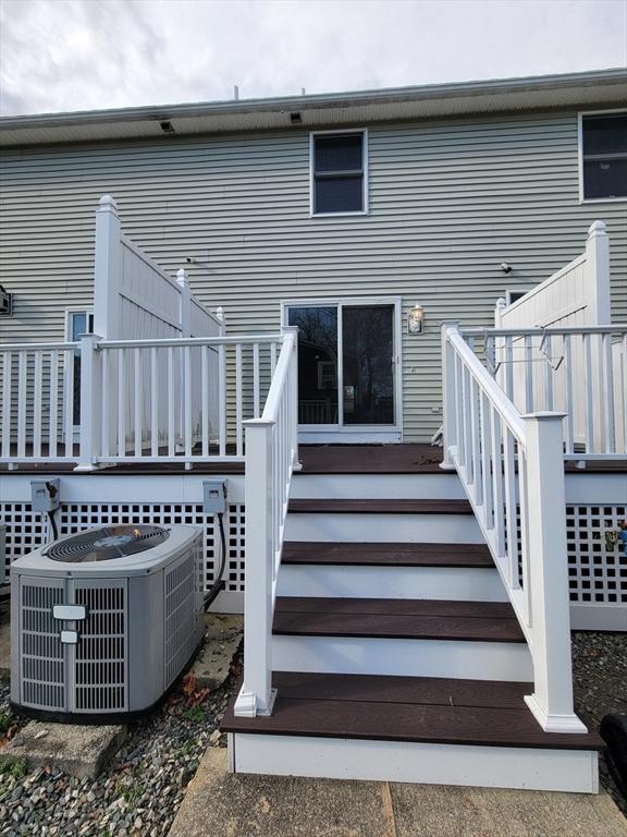 rear view of house featuring cooling unit and a wooden deck