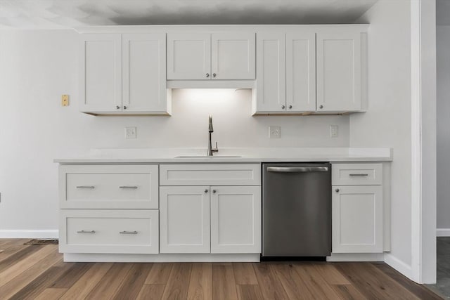 kitchen featuring dark wood-type flooring, dishwasher, sink, and white cabinets