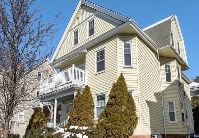 view of property exterior featuring a shingled roof and a balcony