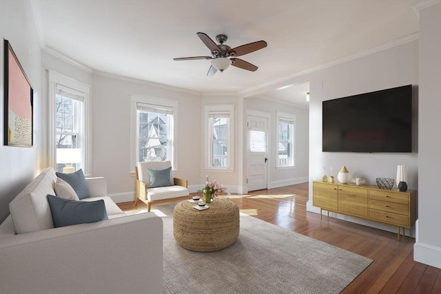 living area featuring plenty of natural light, ornamental molding, and wood finished floors