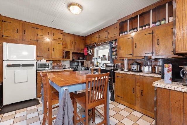 8 Peaceable St, Boston, MA 02135 - kitchen with freestanding refrigerator, brown cabinetry, light countertops, light flooring, and open shelves