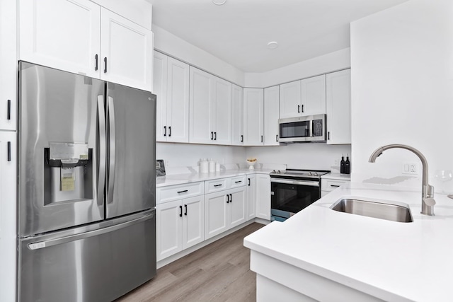 kitchen featuring white cabinetry, light hardwood / wood-style floors, appliances with stainless steel finishes, and sink