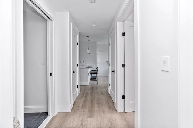 hall featuring light hardwood / wood-style floors and sink