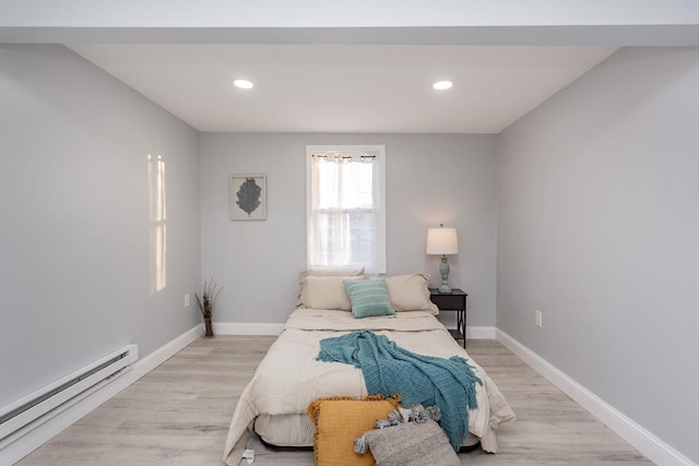 bedroom featuring light hardwood / wood-style flooring and a baseboard heating unit