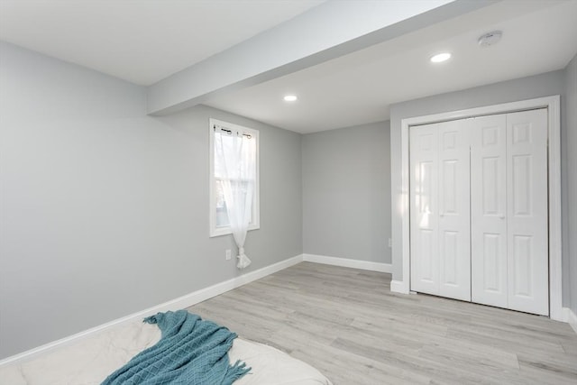 bedroom with light wood-type flooring and a closet