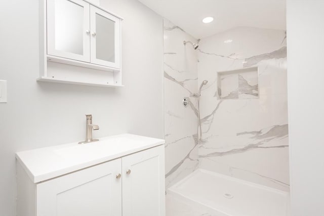 bathroom featuring vanity and tiled shower