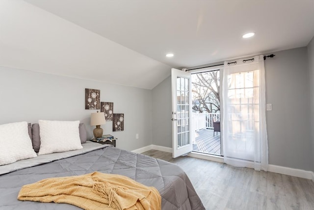 bedroom featuring access to exterior, hardwood / wood-style floors, and lofted ceiling