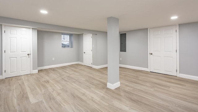 basement with electric panel and light hardwood / wood-style flooring