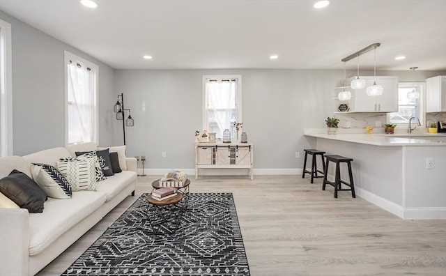 living room with sink and light wood-type flooring