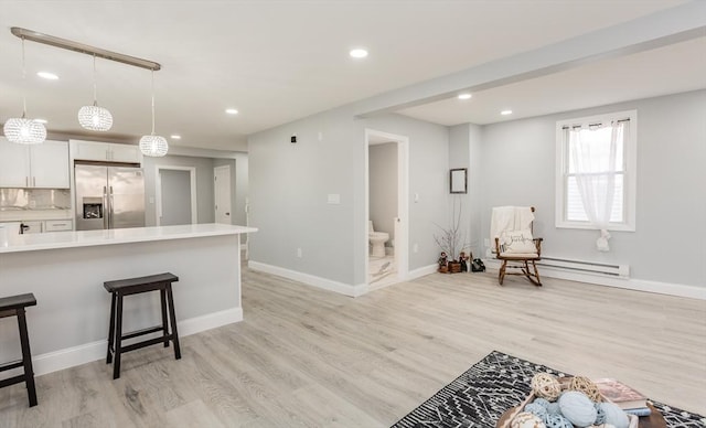 kitchen featuring stainless steel refrigerator with ice dispenser, hanging light fixtures, decorative backsplash, light wood-type flooring, and white cabinetry