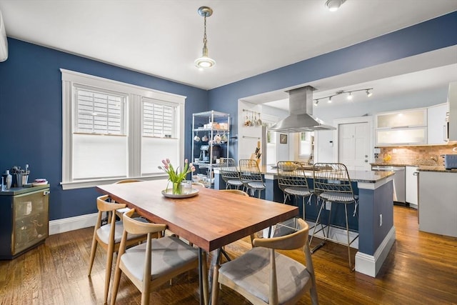 dining room featuring dark wood-type flooring and baseboards