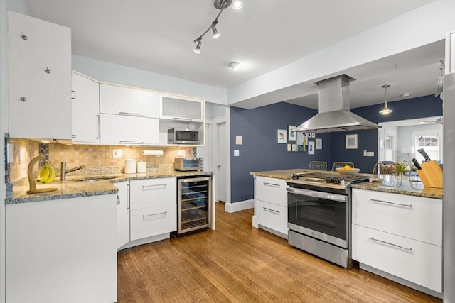 kitchen featuring stainless steel appliances, wine cooler, island exhaust hood, a sink, and light wood-type flooring