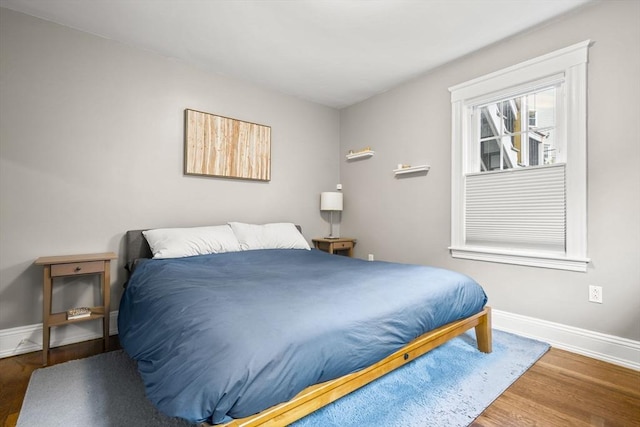 bedroom featuring wood finished floors and baseboards