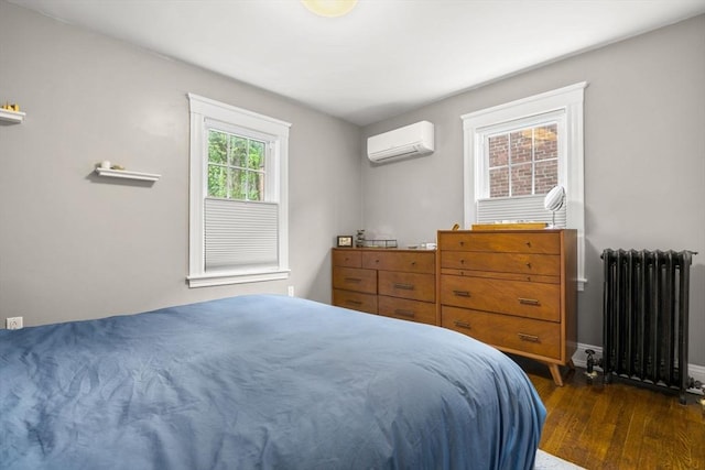bedroom featuring radiator, an AC wall unit, dark wood-style flooring, and baseboards