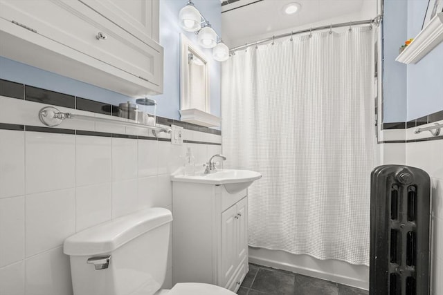 full bath with radiator, tile walls, toilet, shower / bath combo with shower curtain, and tile patterned floors
