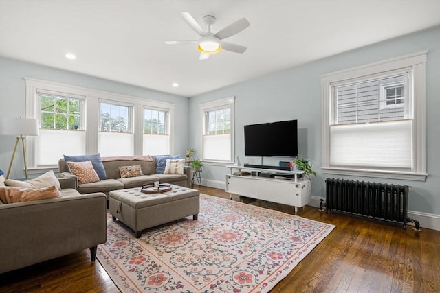 living area with radiator, hardwood / wood-style floors, a ceiling fan, baseboards, and recessed lighting