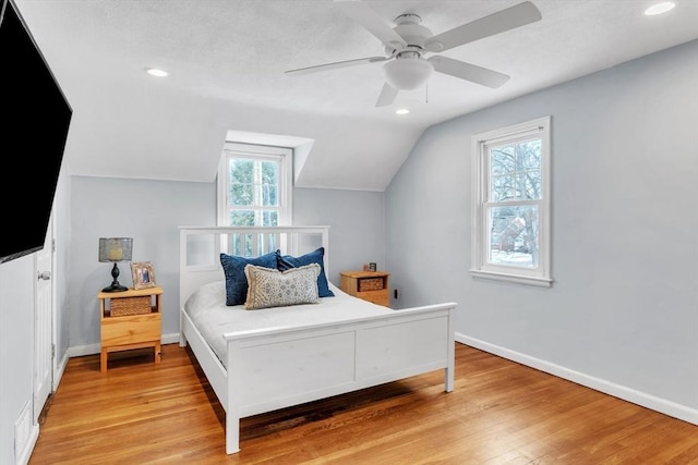 bedroom with lofted ceiling, light hardwood / wood-style flooring, and ceiling fan